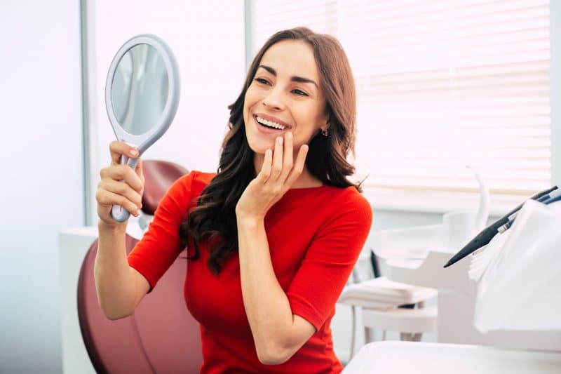 Woman admiring smile after receiving dental implants in Jacksonville